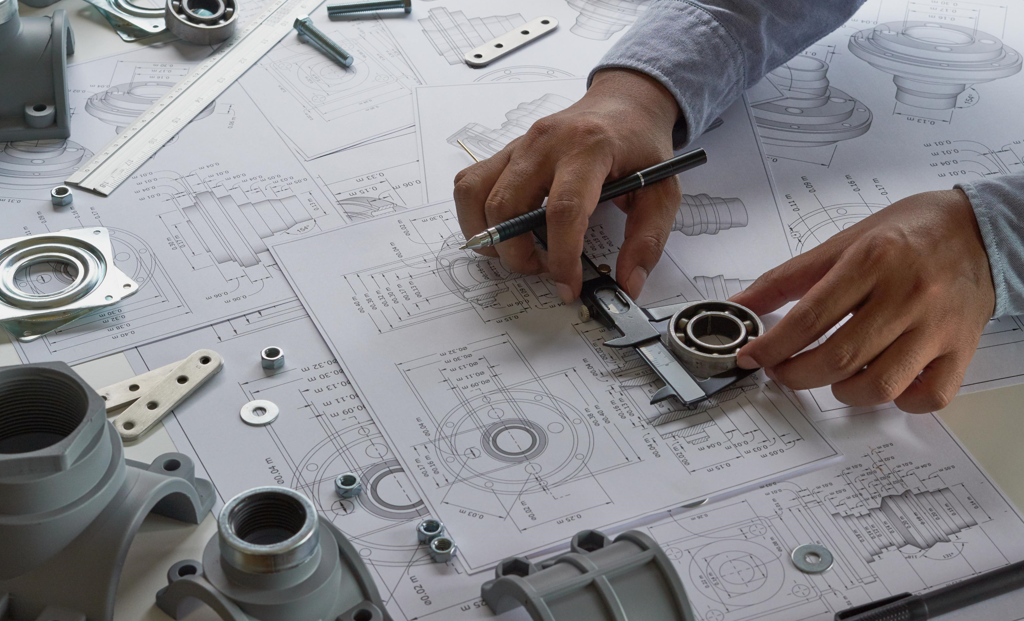 Stock Image_hands with metal part on blueprints-2